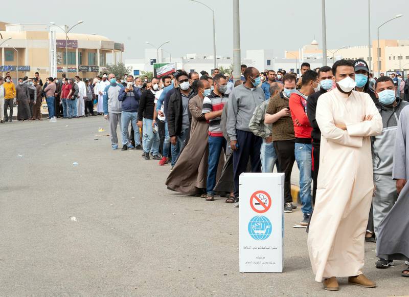 Expatriates wait in line to be tested at a makeshift centre, following the outbreak of coronavirus, in Mishref, Kuwait. REUTERS