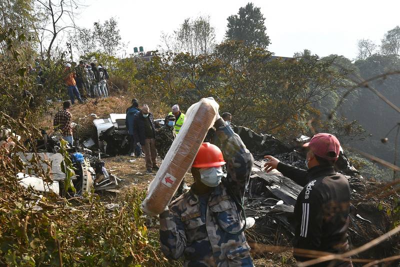 Rescuers inspect the wreckage at the site of a plane crash. AFP