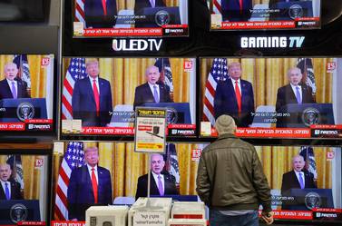An Israeli man watches the televised press conference of US President Donald Trump and Israeli Prime Minister Benjamin Netanyahu at an electronics shop in the Israeli city of Modiin on January 28, 2020. Palestinians staged protests against US President Donald Trump's Middle East peace plan, hours before it was to be unveiled in Washington. Thousands demonstrated in Gaza, burning pictures of Trump and the American flag, while further rallies were planned for the coming days. / AFP / GIL COHEN-MAGEN