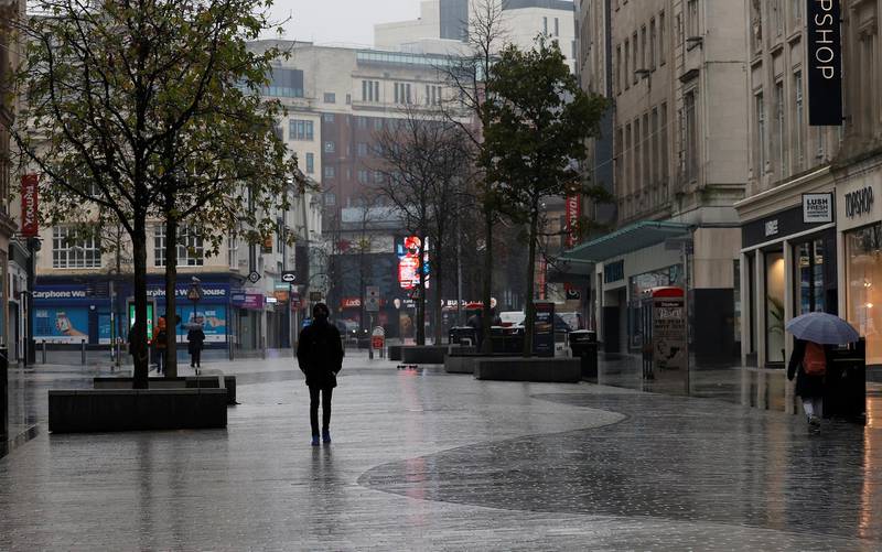 A man walks through a deserted shopping street in Liverpool. Reuters