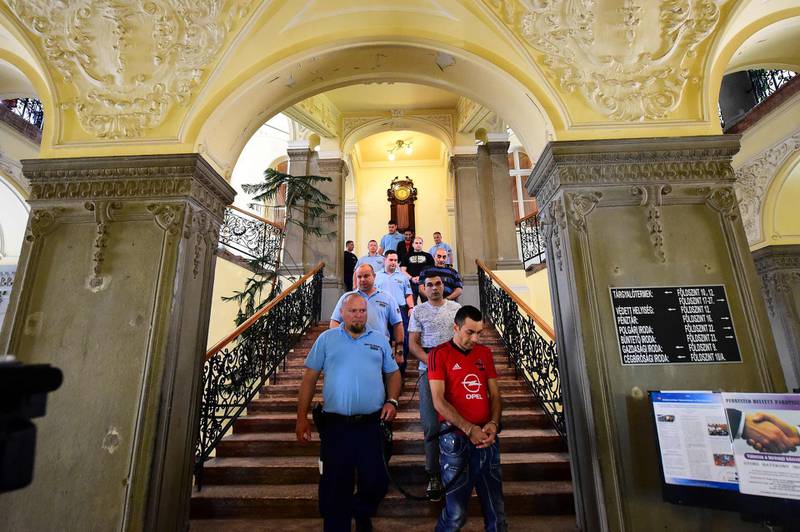 (FILES) In this file photo taken on June 21, 2017 members of an international smuggler group are pictured at a courthouse in Kecskemet, some 80 km from Hungarian capital Budapest, during the opening of a trial in connection with deaths of 71 migrants found in an abandoned truck in Austria in 2015.    The verdict is expected on June 14, 2018 in the trial of 11 men charged over the deaths of 71 migrants found in an truck in Austria in 2015, in one of the most disturbing cases marking Europe's migration crisis  / AFP / ATTILA KISBENEDEK
