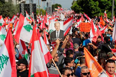 TOPSHOT - A supporter of Lebanese President Michel Aoun holds his picture during a counter-protest near the presidential palace in Baabda on November 3, 2019. Thousands of Lebanese gathered to show support to the embattled president, an AFP correspondent said, after more than two weeks of mass anti-graft protests that brought down the government. / AFP / ANWAR AMRO
