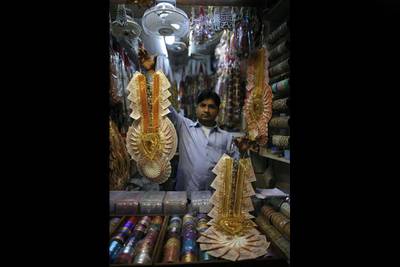 A shopkeeper holds up a wedding garland made from Indian rupee notes in a market of New Delhi. India's rupee plunged more than 3.6 percent to a new record low against the dollar. Maral Deghati / AFP