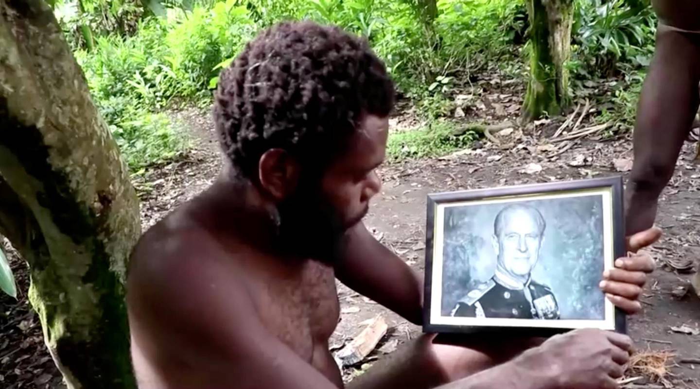 A man holds a picture of Britain's Prince Philip as late Duke's devotees hold a mourning ceremony in his honour on the island of Tanna in Vanuatu in this screengrab taken from a video on April 12, 2021. REUTERS TV via REUTERS
