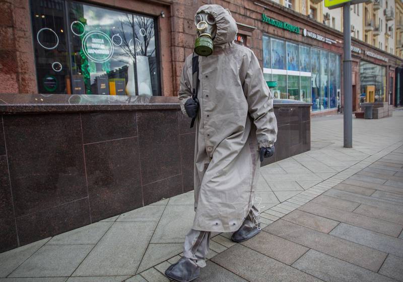A man wears a protective suit and a gas mask as he walks along a street in central Moscow as Moscow city officials have limited public gatherings of more than 50 people and schools across the country will close for three weeks from March 23 in an effort to stop the spread of the COVID-19 infection caused by the novel coronavirus.  AFP