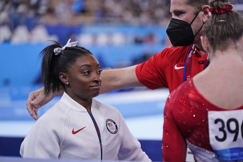 US coach Laurent Landi comforts Simone Biles after she exited the team final at the Tokyo Games on Tuesday, July 27, 2021.