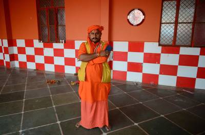 (FILES) In this file photo taken on November 10, 2018, Indian priest Pawan Pandey, 38, poses with his smartphone at a Hanuman temple near the Sangam area in Allahabad. / AFP / SANJAY KANOJIA
