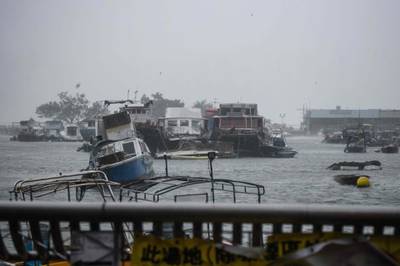 A boat lists in a typhoon shelter in the village of Lei Yu Mun. AFP