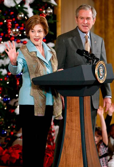 epa01571970 US President George W. Bush and first lady Laura Bush welcome guests during the Children's Holiday Reception and Performance in the East Room of the White House 08 December 2008 in Washington, DC. The reception is for children whose parents are serving the United States and can not be with them for the Christmas holiday.  EPA/Chip Somodevilla POOL