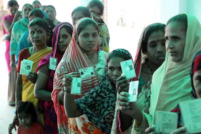 Indian voters show their voter ID cards as they wait in a queue to cast their votes at a polling station during the sixth phase of the Indian parliamentary election in Bhopal, India.  EPA
