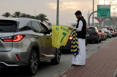 A man sells Cristiano Ronaldo flags and scarves ahead of his unveiling as an Al Nassr player on Tuesday. Reuters
