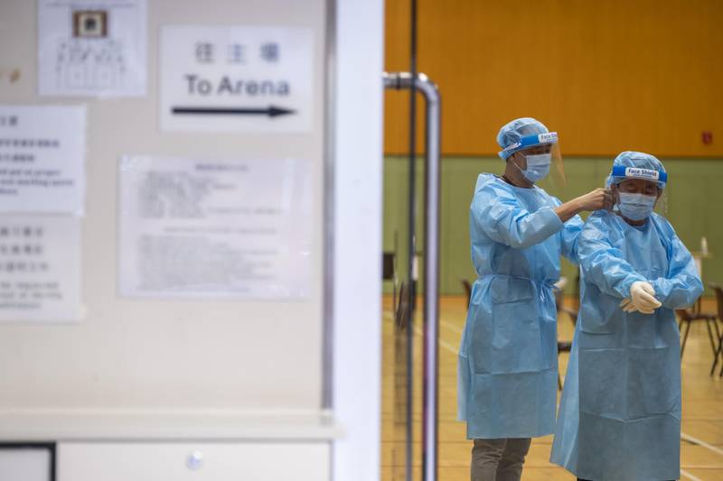 Healthcare workers put personal protective equipment inside a testing centre for the government's Universal Community Testing Programme at Cheung Sha Wan Sports Centre in Hong Kong, China. Bloomberg
