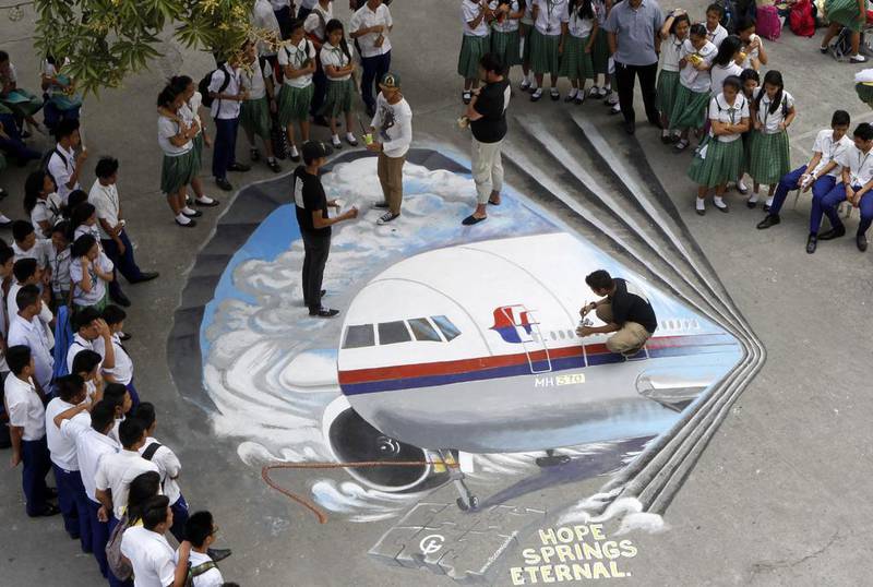 Filipino artists from the Guhit Visual Arts Group paint the image of Malaysia Airlines Flight MH370 at the Benigno Ninoy Aquino High School grounds in Makati City, south of Manila, Philippines, on March 17 to express hope and solidarity for the passengers and crew of the missing jet. Amiel Meneses / EPA