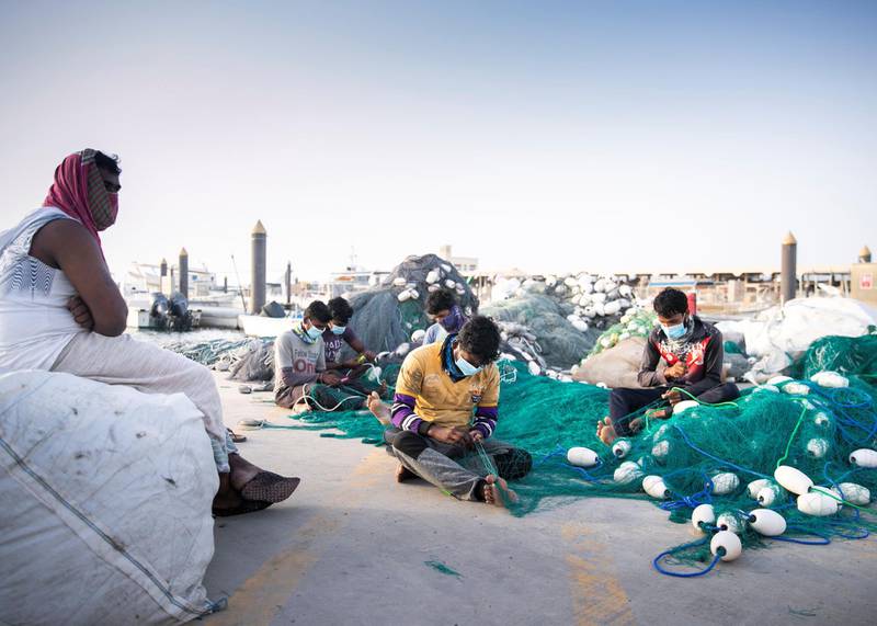 DUBAI, UNITED ARAB EMIRATES. MARCH 2020. A group of men make fishing nets at Jumeirah fishing harbour.The Ministry of Agriculture and Fisheries has closed th fish markets.(Photo: Reem Mohammed/The National)Reporter:Section:
