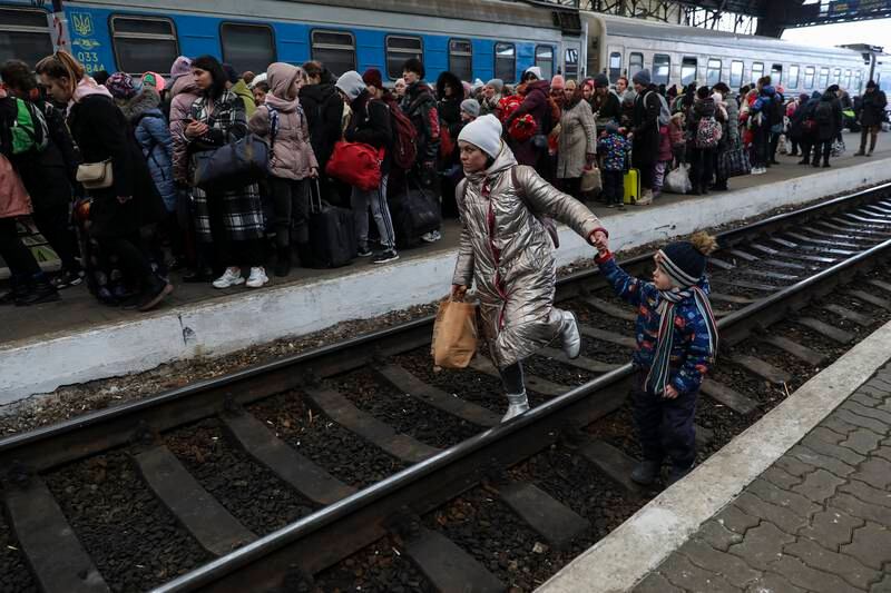 A woman walks with her child as displaced Ukrainians arrive at the Lviv railway station in western Ukraine on March 5. EPA