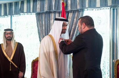 CASABLANCA, MOROCCO - March 17, 2015: HM King Mohammed VI of Morocco (R), presents HH Sheikh Mohamed bin Zayed Al Nahyan Crown Prince of Abu Dhabi and Deputy Supreme Commander of the UAE Armed Forces (C), with The Order of Muhammadi Medal of the First Degree ( Wissam Al Muhammadi ), at the Royal Palace of Casablanca. Witnessing the honor is HH Sheikh Hamdan bin Zayed Al Nahyan UAE Deputy Prime Minister and Ruler of the Western Region (L).( Rashed Al Mansoori / Crown Prince Court - Abu Dhabi )