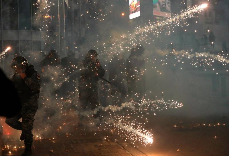 Lebanese riot policemen react to firecrackers that fired by the supporters of the Shiite Hezbollah and Amal Movement groups. AP