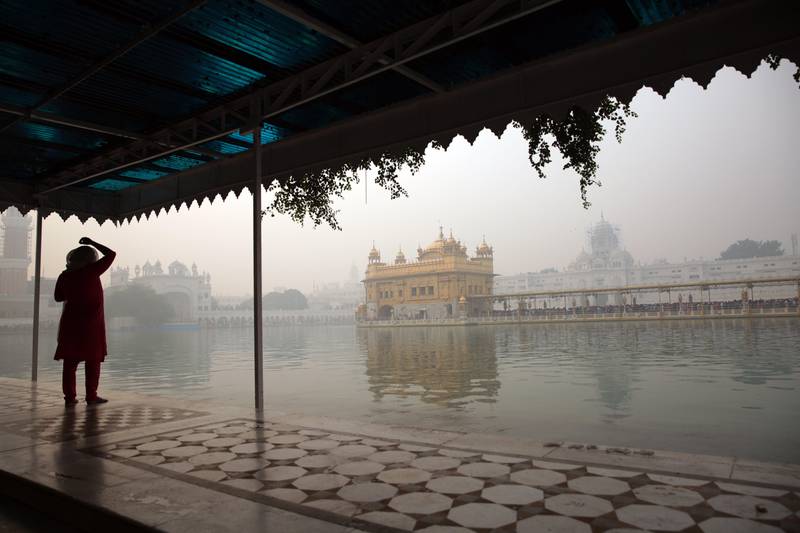 A woman sprinkles holy water, taken from the sacred pond on her head as she visits to pay obeisance at the Golden Temple, the holiest of Sikh shrines on the occasion of the birth anniversary of the first Sikh Guru in Amritsar, India. Raminder Pal Singh / EPA