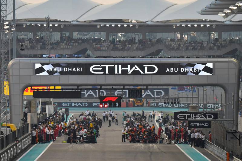 Cars and mechanics are pictured on the grid ahead of the final race of the season. AFP