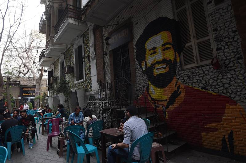 Egyptians gather at a cafe near a graffiti of Egyptian footballer Mohamed Salah in Cairo on March 22, 2018. Fethi Belaid / AFP