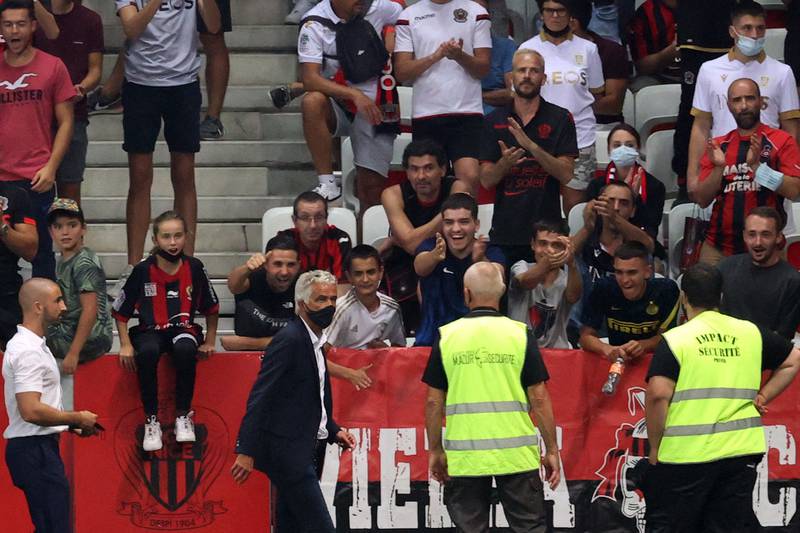 Nice's president Jean-Pierre Rivere (C) makes his way to speak to supporters following the pitch invasion. AFP