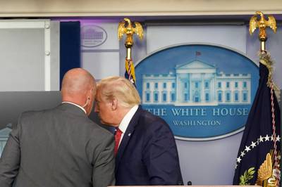 US President Donald Trump talks with a secret service agent before leaving a coronavirus pandemic briefing at the White House in Washington, US. Reuters