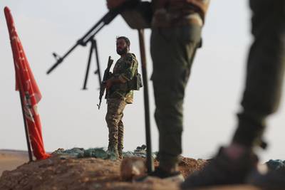 (FILES) In this file photo taken on November 12, 2018 an Iraqi Shiite fighter of the Hashed al-Shaabi paramilitary force secures the border in al-Qaim in the Anbar province, opposite Albu Kamal in Syria's Deir Ezzor region.  An air strike killed 26 fighters of Iraqi paramilitary group Hashed al-Shaabi in eastern Syria after a deadly attack on US-led coalition troops in Iraq, a war monitor said on March 12, 2020. Updating its toll for the Marcg 11 strike, the Britain-based Syrian Observatory for Human Rights said it was probably carried out by the coalition. The coalition did not immediately provide comment. Before the strike near the border town of Albu Kamal, rockets were fired at a military base north of Baghdad hosting coalition troops, killing two Americans and one Briton.
 / AFP / AHMAD AL-RUBAYE
