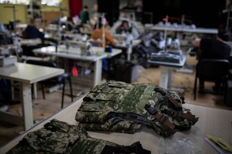 A pile of freshly made military vests sit on a table in a makeshift factory in Mykolaiv.