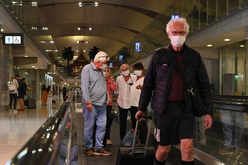 This photo taken on February 23, 2020 shows passengers wearing protective facemasks, amid concerns of the spread of the COVID-19 novel coronavirus, at the arrival area of Suvarnabhumi Airport in Bangkok. / AFP / Romeo GACAD
