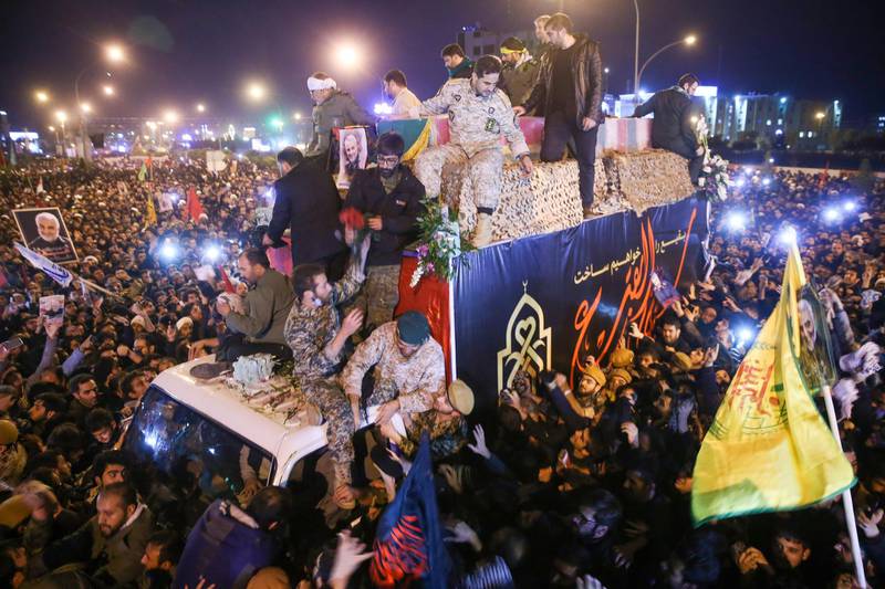 Iranians gather around a vehicle carrying the caskets of Qassem Suleimani and others during a funeral procession after the bodies arrived in the northeastern city of Qom following a ceremony in the capital Tehran.  AFP