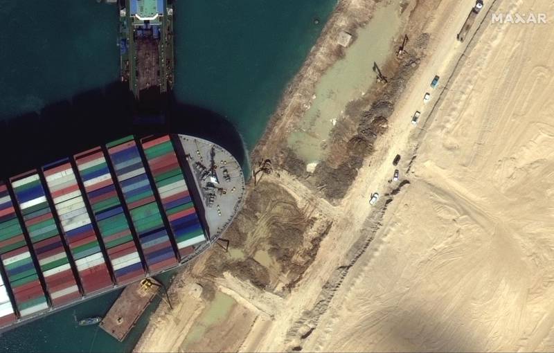 A view of the earth moving equipment excavating sand near the bow of the Ever Given container ship in Suez Canal in this Maxar Technologies satellite image. Reuters