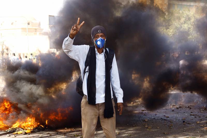 A Sudanese protester stands in front of a blazing fire during a demonstration against the military coup in Khartoum, on March 8. Reuters