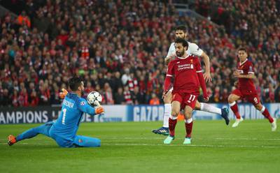 Liverpool's Mohamed Salah scores his sides second goal past Roma's Alisson Becker. Clive Brunskill / Getty Images