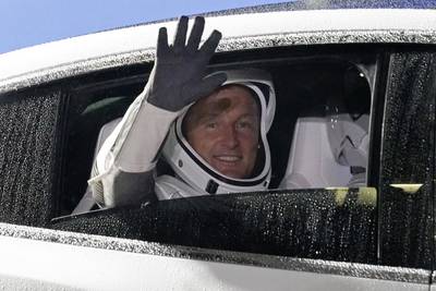 Matthias Maurer waves as he heads for the launch pad in a Tesla. AP