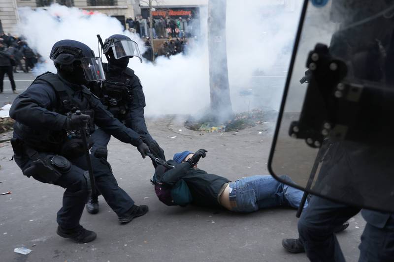 A protester is dragged away by riot police. AP