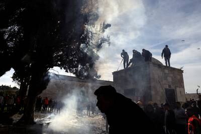 Palestinians put out a fire following violence between Israeli security forces and demonstrators at Al Aqsa Mosque compound in Jerusalem's Old City. Reuters