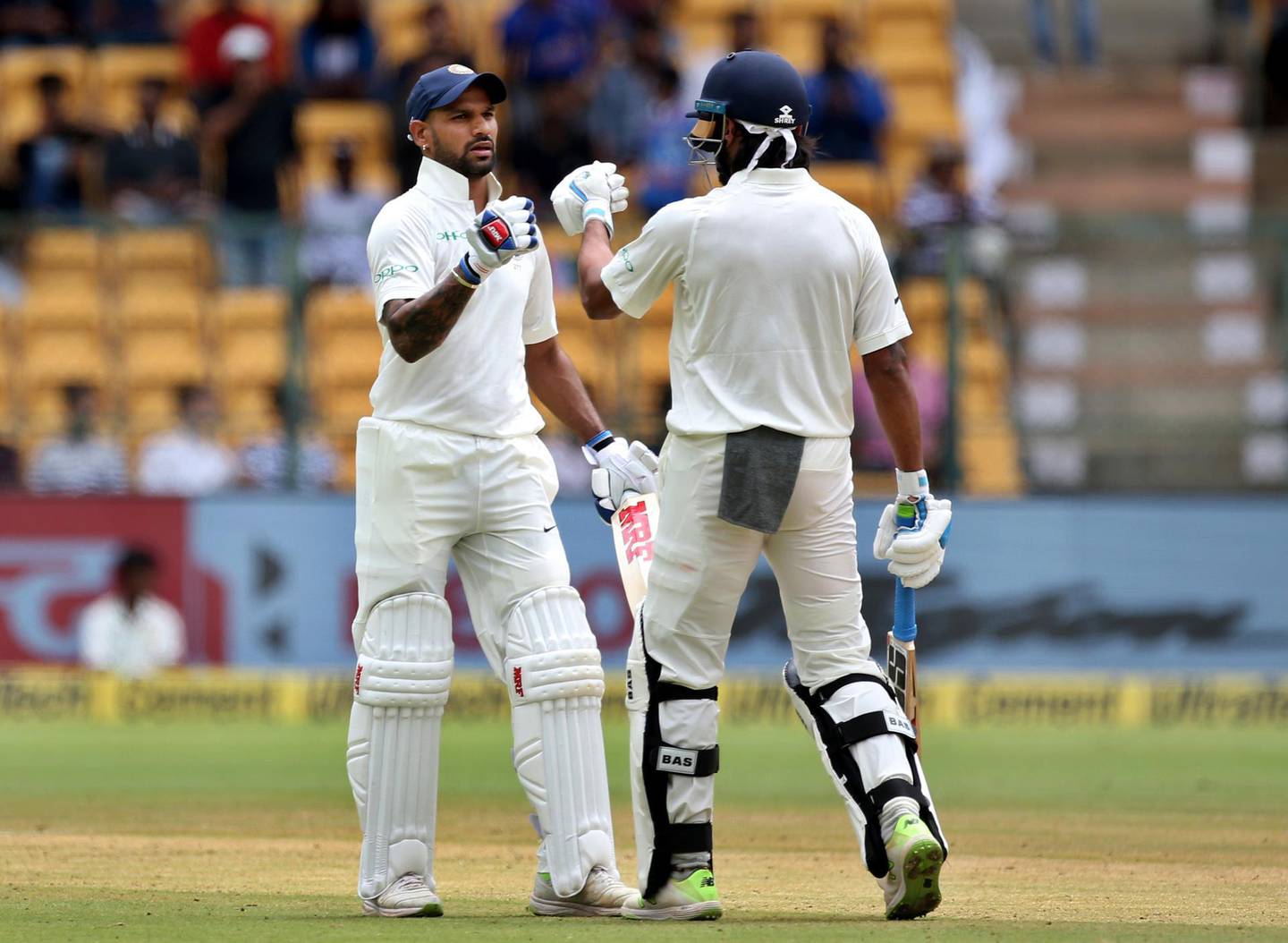 India's Murali Vijay, right, greets teammate Shikhar Dhawan, left, on hitting a boundary during the one-off cricket test match against Afghanistan in Bangalore, India, Thursday, June 14, 2018. (AP Photo/Aijaz Rahi)