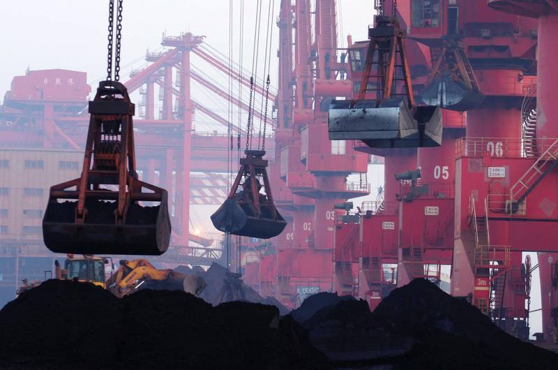 FILE - In this June 6, 2015, file photo, heavy machines move imported iron ore at the dock in Rizhao in eastern China's Shandong province.  China announced Monday, Aug. 14, 2017,  it will cut off imports of North Korean coal, iron ore and other goods in three weeks under U.N. sanctions imposed over the Northâ€™s nuclear and missile programs.(Chinatopix via AP, File)