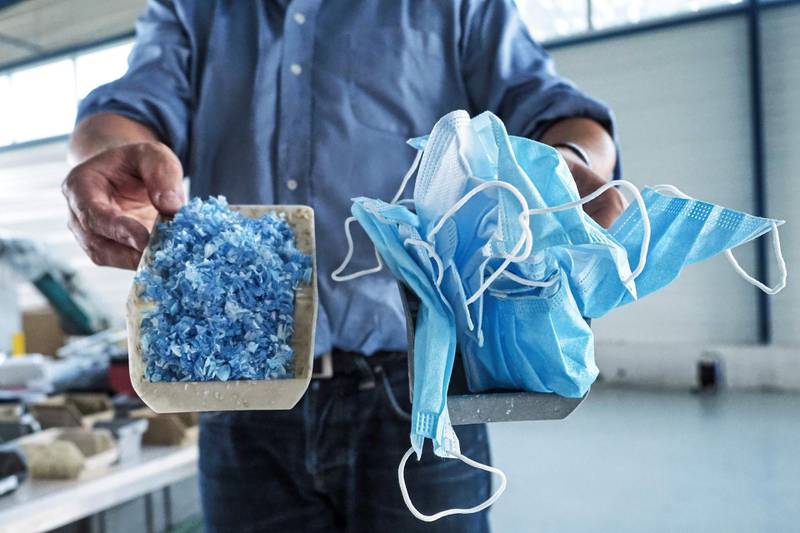 Co-founder of Plaxtil, Olivier Civil, shows the transformation of protective face masks into shredded material 'Plaxtil', a combo of plastic and textile, which is used to make visors, door openers, mask fasteners in Chatellerault, western France.  AFP