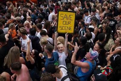 People gather near Parliament in central London during a '#FreedomToDance' march organised by Save Our Scene, calling for an easing of restrictions for music events.