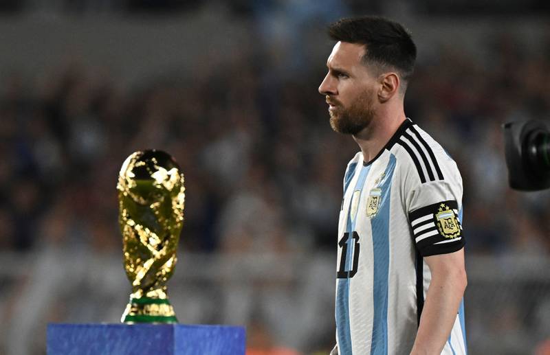 Argentina forward Lionel Messi walks past the World Cup trophy before the friendly football match against Panama. AFP