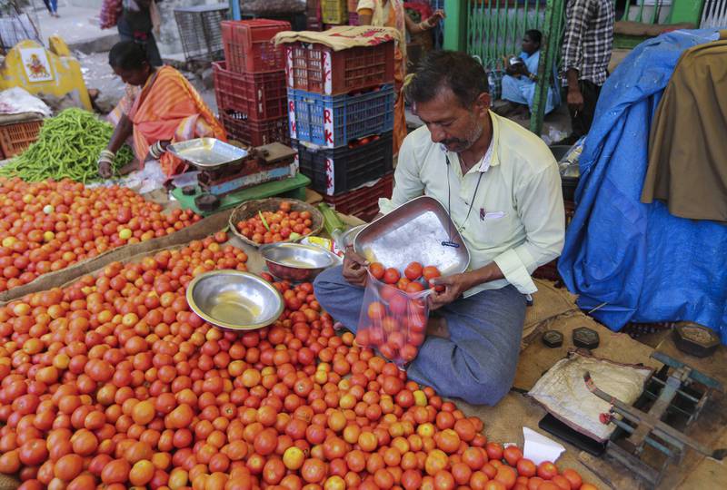 A vendor puts tomatoes in a single-use plastic bag in Hyderabad. AP