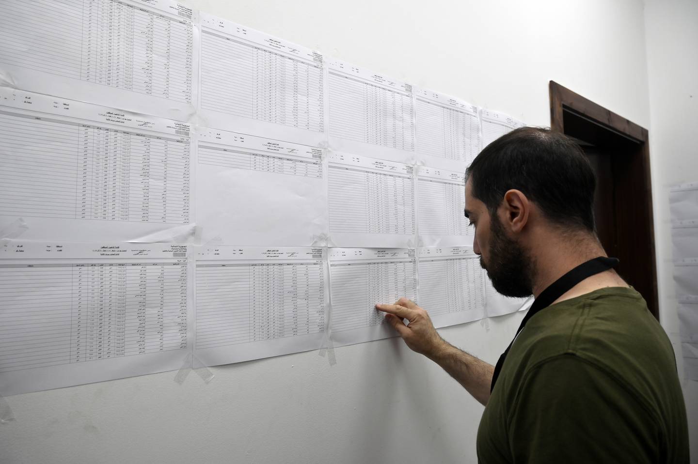 A Lebanese government employee searches for his name in the voting lists to cast his ballot at a polling station in Beirut. EPA