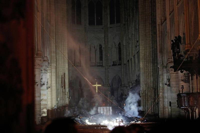 Smoke rises around the altar in front of the cross inside the Notre Dame Cathedral as a fire continues to burn in Paris, France, April 16, 2019.   REUTERS/Philippe Wojazer/Pool     TPX IMAGES OF THE DAY