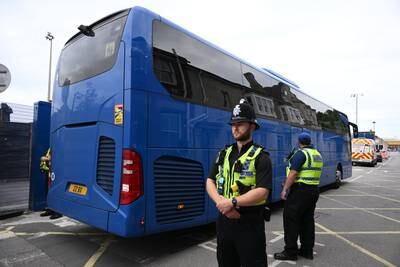 Police stand guard as a coach arrives. Getty Images