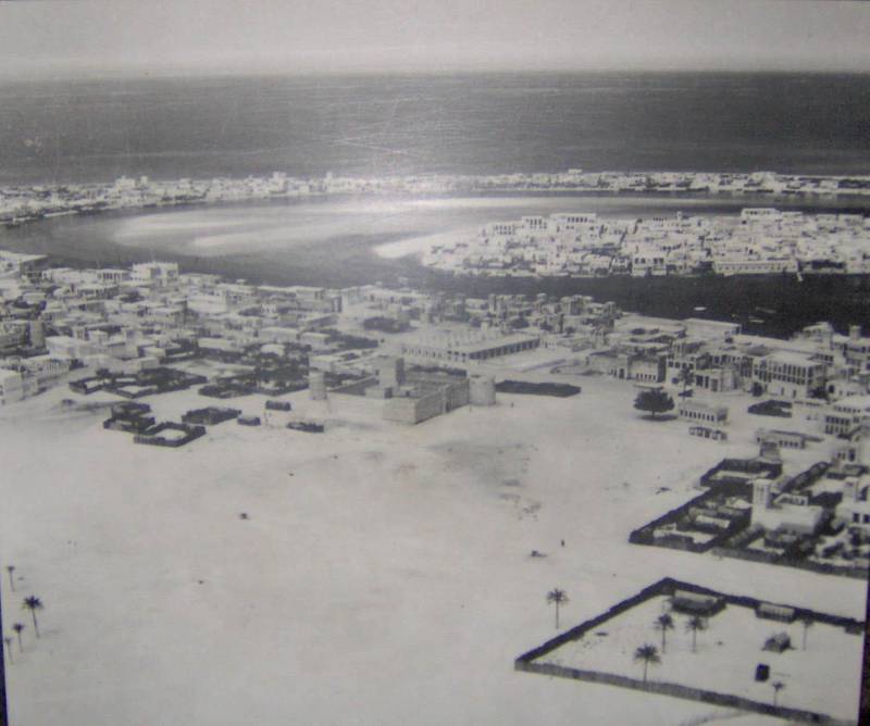 Dubai in 1950. Al Fahidi Fort in Bur Dubai can be seen in the foreground, with Deira in the middle-right on the other side of the creek. Al Shindagha (left) and Al Ras (right) are in the background across the creek again from Deira.