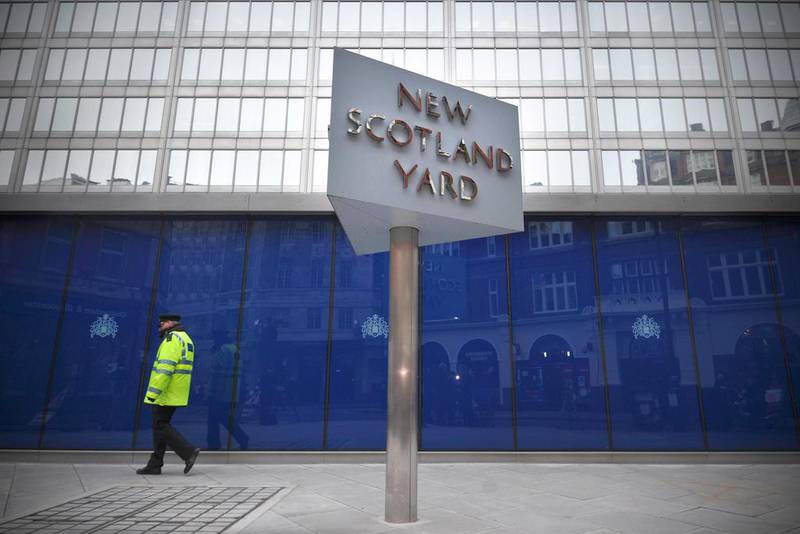 A police support officer walks past a sign outside New Scotland Yard, the headquarters of the Metropolitan Police, in central London. Abu Dhabi Financial Group  acquired the property for £370 million (Dh2.1 billion) last year. The company plans to redevelop the 600,000 square foot site in Central London into a world-class multi-use development. Carl Court / AFP