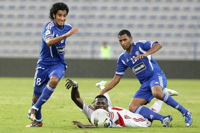 Ibrahim Diaky, centre, tumbles between Ali Abbas, left, and Mahmoud Darwish, right, whose Al Nasr side are unbeaten in six games.