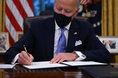US President Joe Biden signs a series of orders in the Oval Office of the White House in Washington, DC, after being sworn in at the US Capitol on January 20, 2021. / AFP / Jim WATSON