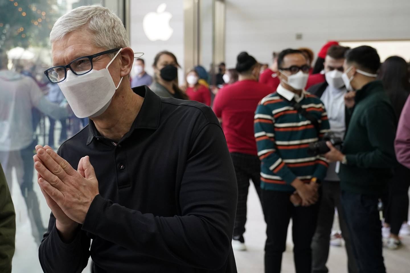 Apple's chief executive Tim Cook, who earned more than $98.7 million in salary last year, talks with customers during a visit to an Apple Store in Los Angeles. AP